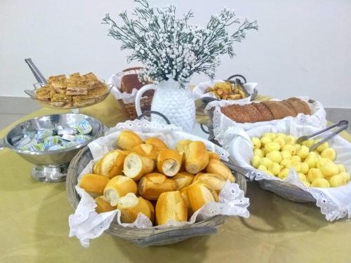 een tafel met drie manden brood en andere voedingsmiddelen bij Hotel Picadão - São Pedro SP in São Pedro