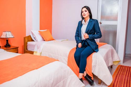 a woman sitting on a bed in a hotel room at Hotel Chachapoyas in Chachapoyas