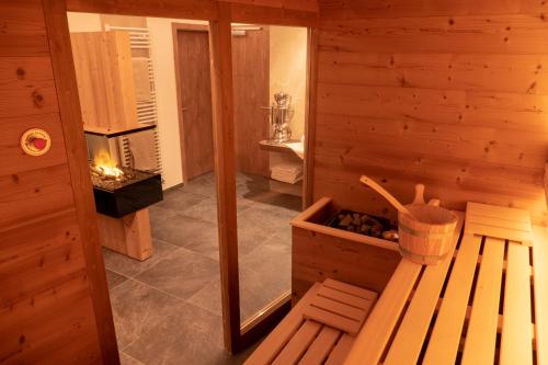 um quarto com uma sauna com um banco e uma lareira em Villa Artic Apartments em Campitello di Fassa