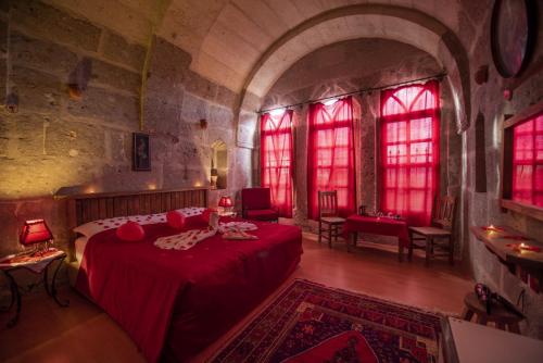 a bedroom with a red bed in a castle at Kapadokya Ihlara Konaklari & Caves in Guzelyurt