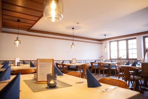 a dining room with tables and chairs and windows at Hotel Falk in Krumbach