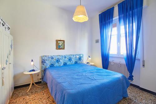 a bedroom with a blue bed and blue curtains at Borgomare in Finale Ligure