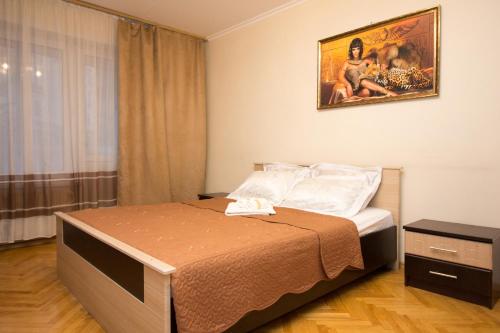モスクワにあるApartment on Elninskaya 15のベッドルーム1室(ベッド1台付)が備わります。壁には絵画が飾られています。