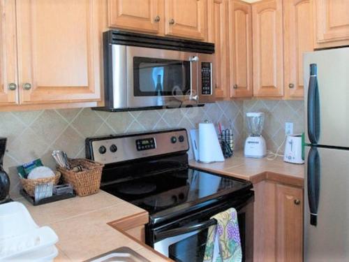 a kitchen with a stove and a microwave at Windsong on the Reef in Grace Bay