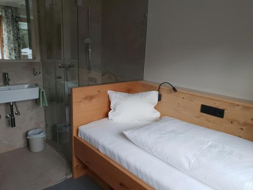 a bedroom with a bed with a shower and a sink at Gästehaus Wallner in Kitzbühel