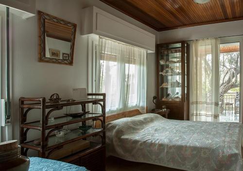 1 dormitorio con cama y espejo en la pared en Marathos beach House en Marathón