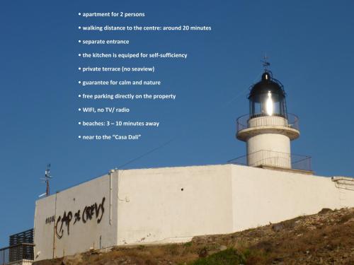 a lighthouse on top of a hill with writing on it at Apartment Hibiscus Cadaqués in Cadaqués
