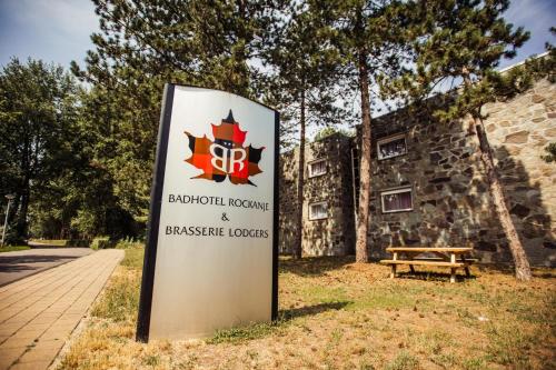 a sign in front of a building with a bench at Badhotel Rockanje in Rockanje