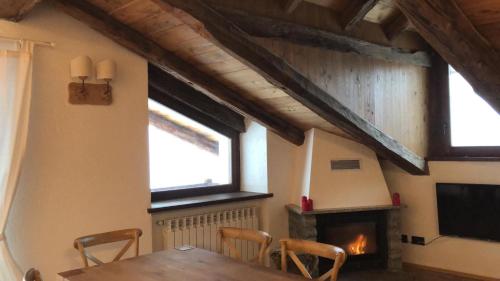 a dining room with a table and a fireplace at Chalet Morge in La Salle