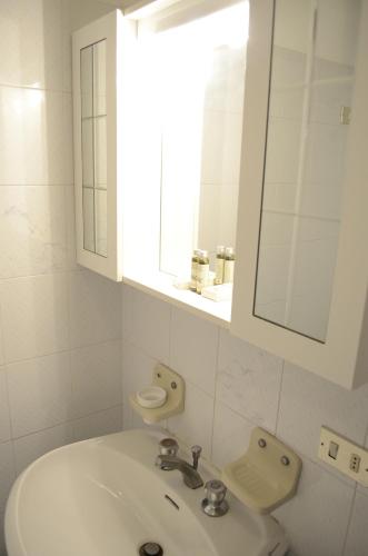 Baño blanco con lavabo y espejo en Appartamenti Le Spiagge, en Marciana Marina