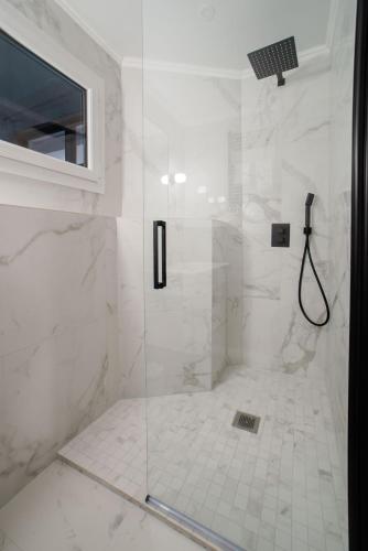 une salle de bain avec une douche avec une porte vitrée dans l'établissement SUITE DESNOS : au cœur de la Rive Gauche, neuf, design, 2 personnes, à Paris