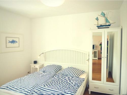 een slaapkamer met een bed met blauwe en witte gestreepte kussens bij Ferienwohnung Beach Loft im Haus Kühlung in Kühlungsborn