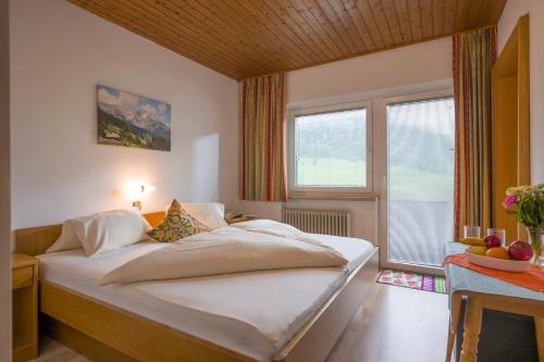 a bedroom with a large bed with a window at Haus Gratz in Söll