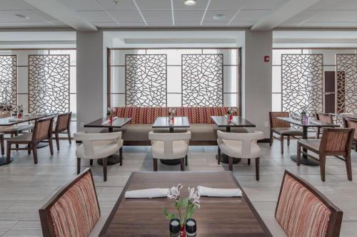 a restaurant with tables and chairs and windows at Holiday Inn Mishawaka by IHG in Mishawaka