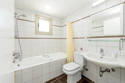 Un baño con inodoro, lavabo y bañera. en Sunrise Bay Villa #1, en Protaras