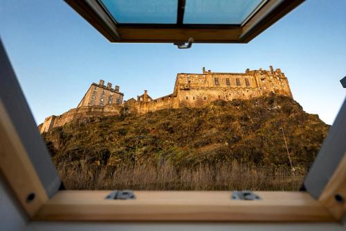 a view of a castle from inside a window at Wilde Aparthotels Edinburgh Grassmarket in Edinburgh