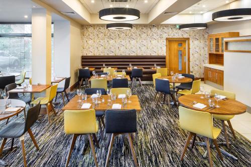 a dining room with tables and chairs in a room at Mercure Sheffield Parkway in Sheffield