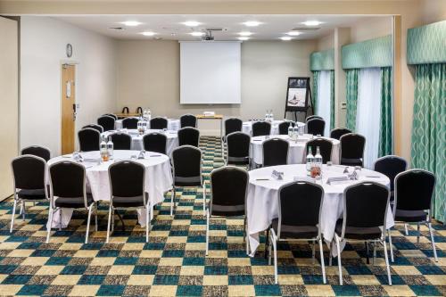 a conference room with tables and chairs and a screen at Mercure Sheffield Parkway in Sheffield