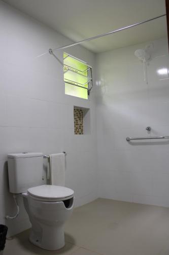 a white bathroom with a toilet and a mirror at Estância Solazer in Santa Isabel