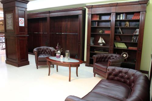 a living room with a leather couch and a table at Hotel Skala in Belgrade