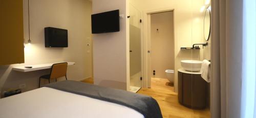 a room with a bed and a bathroom with a sink at Albergo Centrale in Lamezia Terme
