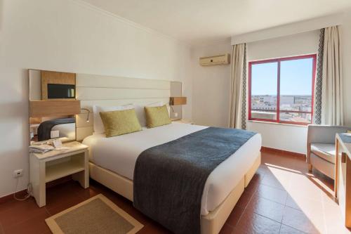 a hotel room with a large bed and a window at Best Western Hotel Dom Bernardo in Faro