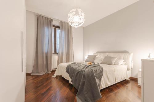 Habitación blanca con cama y lámpara de araña. en Welcome to Milan and More!, en Varedo
