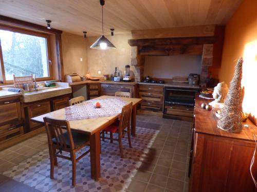 une grande cuisine avec une table et des chaises en bois dans l'établissement Le Shamballa, à Le Monteil-au-Vicomte