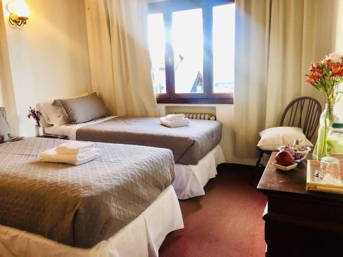 a hotel room with two beds and a window at Kalken Hotel by MH in El Calafate