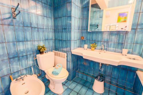 ニースにあるLe Francia Niceの青いタイル張りのバスルーム(トイレ、シンク付)