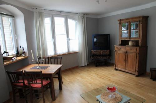 a living room with a table and chairs and a television at Am Bungert in Mayschoß