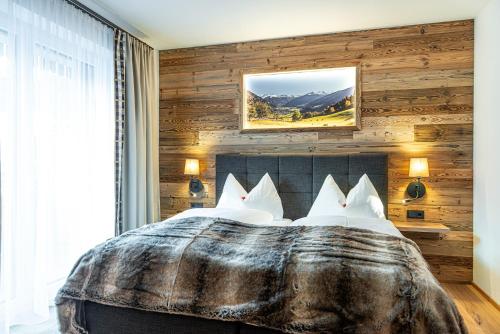 1 dormitorio con 1 cama con pared de madera en Winklers Gipfelblick Chalet, inklusive Alpentherme - Ganzjährig, Gasteiner Bergbahn - nur Sommer en Bad Hofgastein