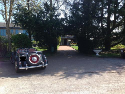 an old fashioned car parked in a driveway at La Berteliere, The Originals Relais in Saint-Martin-du-Vivier
