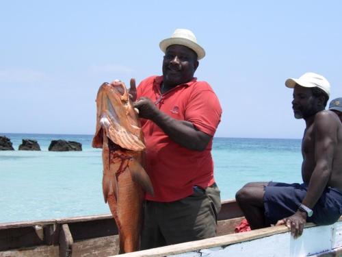 a man holding a fish on a boat at Casa del Sol Bed and Breakfast in Contadora