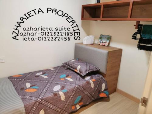 a bedroom with a bed with a quilt on it at D'Sunset Guesthouse TIMURBAY SEAFRONT -KUANTAN in Kuantan
