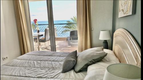 a bedroom with a bed with a view of the ocean at MI CAPRICHO A17 Beachfront Apartment in La Cala de Mijas