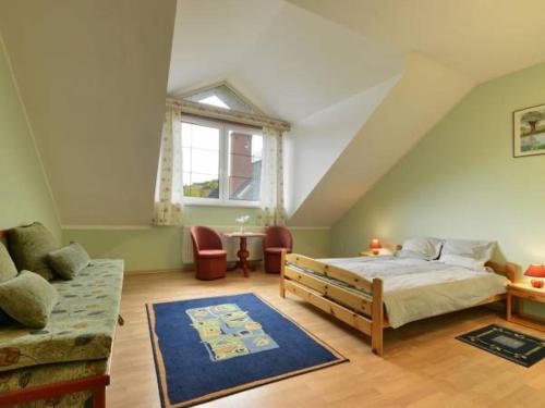 sypialnia z łóżkiem, kanapą i oknem w obiekcie Villasol w Polanicy Zdroju