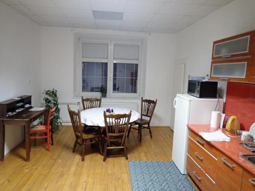 a kitchen with a table and chairs and a kitchen with a refrigerator at Penzion Leticia in Strakonice