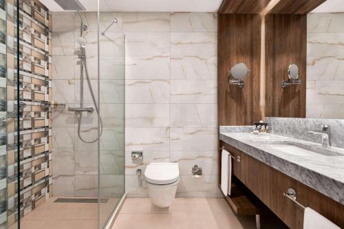 a bathroom with a toilet and a glass shower at Ramada by Wyndham Beylikduzu in Istanbul