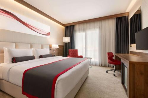 a hotel room with a large bed and a television at Ramada by Wyndham Beylikduzu in Istanbul