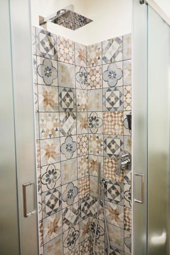 a shower stall with a tiled wall at Una Chicca a Roma in Rome