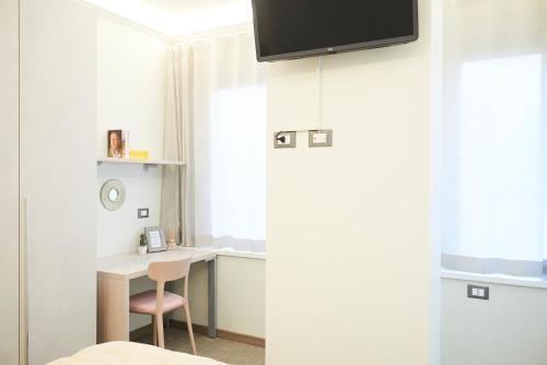 a room with a desk and a monitor on the wall at Una Chicca a Roma in Rome