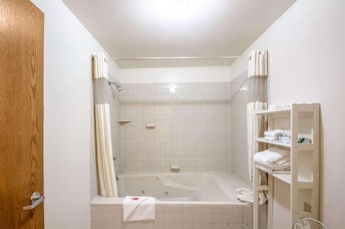 a white bathroom with a tub and a shower at Econo Lodge Waupaca in Waupaca
