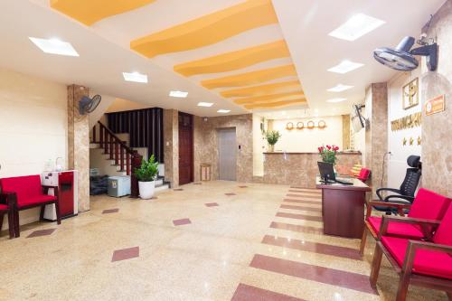 a lobby with red chairs and a staircase at Titanic 2 Hotel in Hanoi