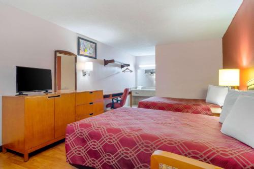 ein Hotelzimmer mit 2 Betten und einem Flachbild-TV in der Unterkunft Econo Lodge in Decatur