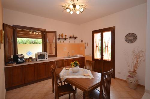 a kitchen with a wooden table and a table and chairs at Aurora Castelluzzo in Castelluzzo