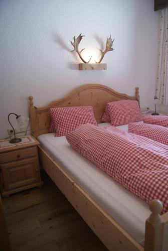 a bedroom with two beds with red and white sheets at Bichlhof in Niederthai