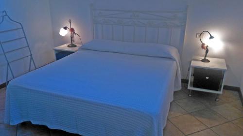 1 dormitorio con 1 cama con sábanas azules y 2 lámparas en Casa Gaia con vista Mare en Olbia