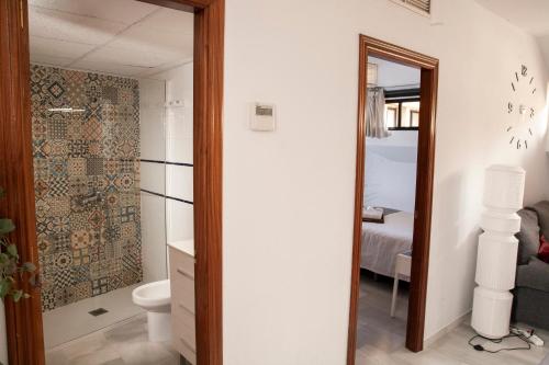 ein Badezimmer mit einem WC, einem Waschbecken und einem Spiegel in der Unterkunft El Mirador de la Judería in Córdoba