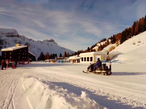 a person riding a snowmobile on a snow covered slope at Piccolo Igloo in Falcade